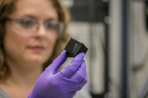 Lab researcher Jennifer Rodriguez examines a 3D-printed box that was programmed to fold and unfold when heated. The box is made of shape-memory polymer inks developed by the team at Lawrence Livermore National Laboratory. Learn more about 4D printing applications in the Prospector Knowledge Center.