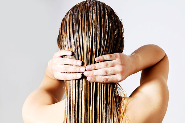 Woman washing her hair - learn how the pH of shampoo influences its efficacy in the UL Prospector Knowledge Center.