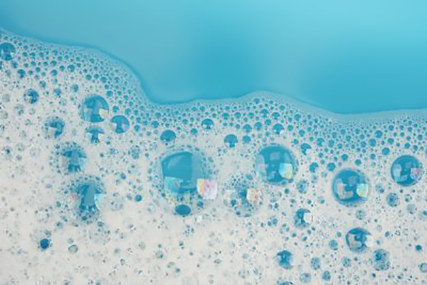Bubble foam on blue water surface - Learn more about defoamers here.