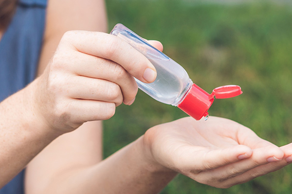 Photo of a woman using hand sanitizer - Learn more about sanitizers