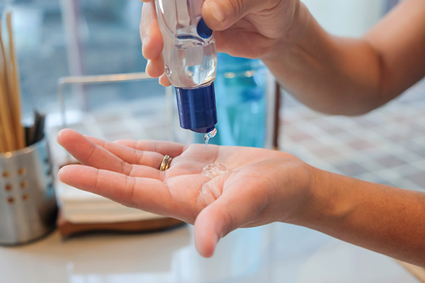 woman applying hand sanitizer - Learn more about hospital-grade hand sanitizers