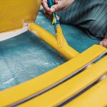 woman painting a chair with yellow paint - Structure and Behavior of Wetting Agents