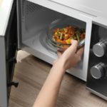 Hand reaching into microwave
