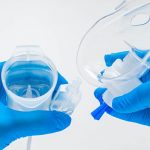 photo of a person wearing medical gloves holding a nebulizer