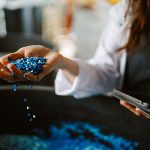A person spilling plastic pellets out of their hand
