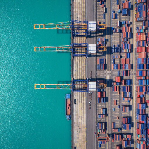 Aerial view of Containerized Cargo Handling and Freight Transportation. Industrial import-export port prepare to load containers.