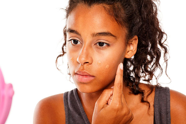 Young woman applying foundation - learn about formulation multifunctional cosmetics in the Prospector Knowledge Center.