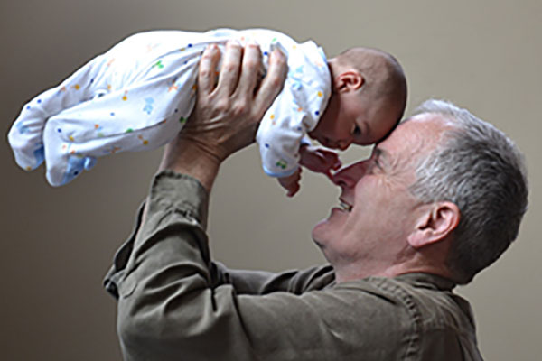 Grandfather holding baby - learn about nutritional needs of older adults in the Prospector Knowledge Center.