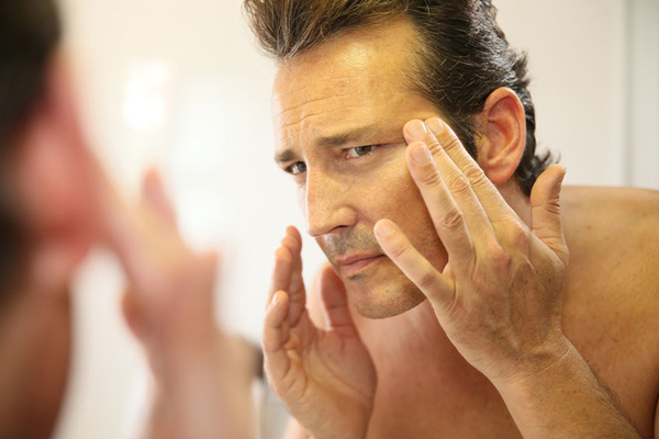 man applying face cream- learn about male skin and hair care product formulations