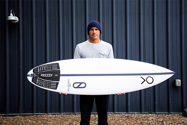 U.S. professional surfing champion Kelly Slater is shown here with a surfboard that incorporates Algix’s Bloom material as a black traction pad.