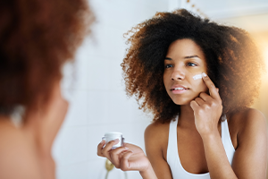 Woman putting on lotion