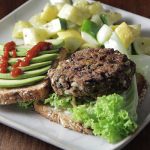 Black bean burger with avocado on plate - learn about how to increase nutritional value with blended proteins in the Prospector Knowledge Center