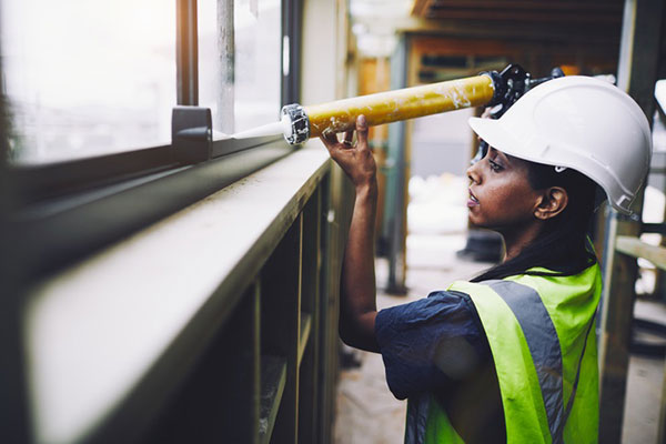 Woman using a sealant - find out more about caulks and sealants here