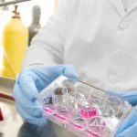 Scientist in lab with test tubes