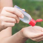 Photo of a woman using hand sanitizer - Learn more about sanitizers