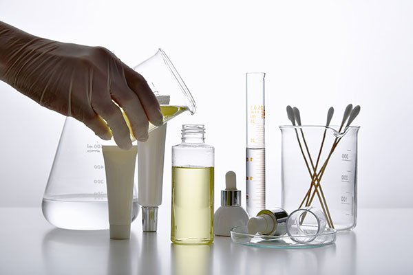 Chemists hand pouring liquid into a beaker