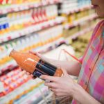 A person looking at the label on a bottle