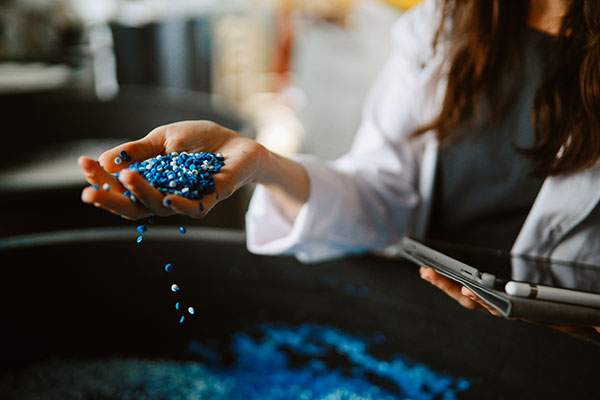 A person spilling plastic pellets out of their hand