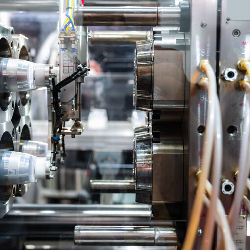 Injection moulding machine working in factory used for the forming of plastic parts using plastic resin and polymers.
