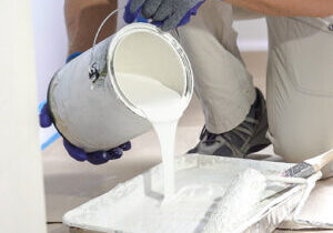 Worker pouring white paint